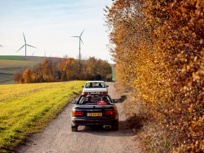 Toyota Celica Convertible en Mercedes-Benz W124 Coupé rijden richting windmolens