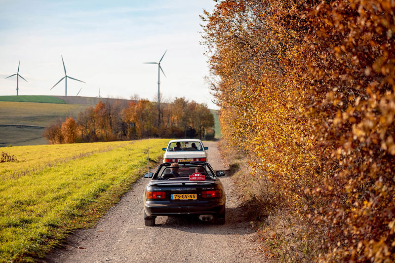 Toyota Celica Convertible en Mercedes-Benz W124 Coupé rijden richting windmolens